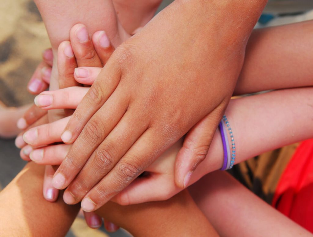children with hands touching together